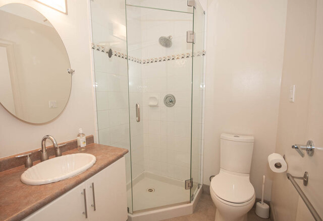 Spacious bathroom with a glass shower, granite countertop, and modern fixtures. - 308 - 1688 Cypress Street, Vancouver West Side