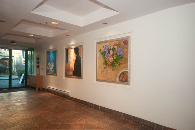 Spacious living room with large windows, modern art on walls, and tiled flooring. - 308 - 1688 Cypress Street, Vancouver West Side