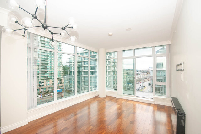 Spacious living room with hardwood floors and stunning city views. - 912 - 175 Victory Ship Way, North Vancouver