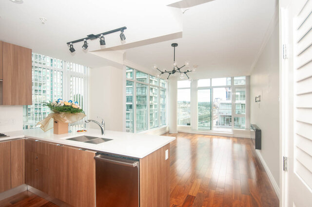 Bright kitchen with modern island, hardwood floors, and a stunning city view. - 912 - 175 Victory Ship Way, North Vancouver