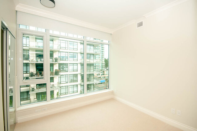 Spacious living room with large windows offering a stunning city view. - 912 - 175 Victory Ship Way, North Vancouver