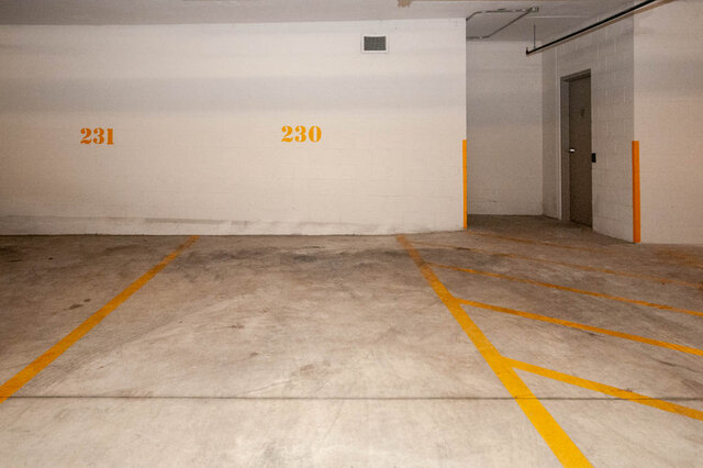 Spacious garage with numbered parking spaces and concrete floor. - 912 - 175 Victory Ship Way, North Vancouver