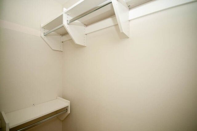 Walk-in closet with built-in shelves and hanging rods. - 912 - 175 Victory Ship Way, North Vancouver