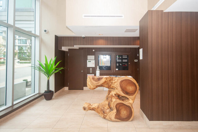 Modern condo entry with natural wood accents and a sleek, open design. - 912 - 175 Victory Ship Way, North Vancouver