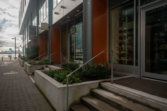 Modern 2-bedroom condo with steps leading to a stylish entrance, featuring a cozy outdoor seating area. - 912 - 175 Victory Ship Way, North Vancouver