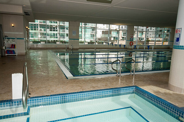 Spacious indoor pool with city view and tiled edges. - 912 - 175 Victory Ship Way, North Vancouver