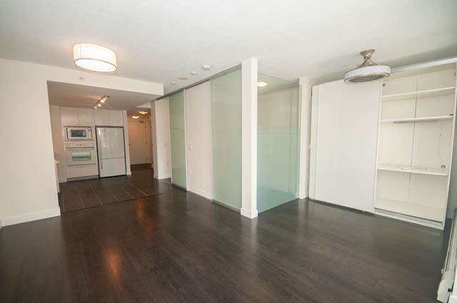 Bright living room with hardwood floors and glass-enclosed closet. - 103 - 175 West 2nd, North Vancouver