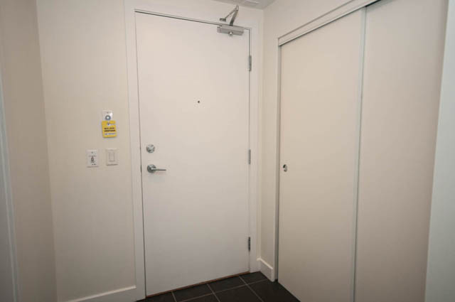 Furnished 1-bedroom entryway with white door and sliding closet doors. - 103 - 175 West 2nd, North Vancouver