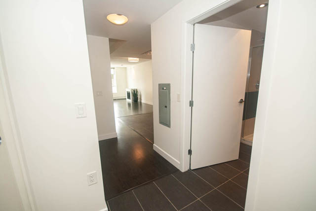 Bright hallway with dark tiled floors and white walls. - 103 - 175 West 2nd, North Vancouver