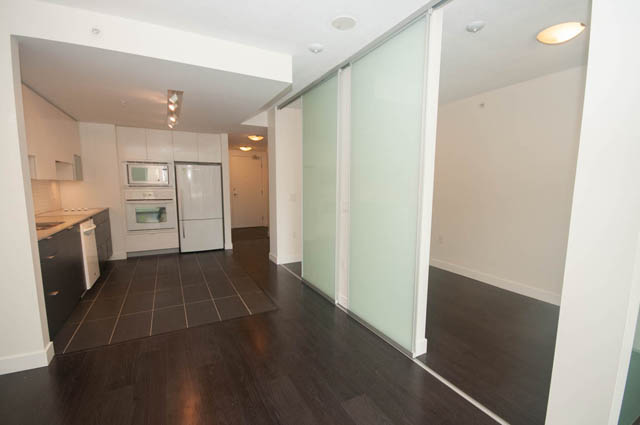 Bright kitchen with dark hardwood floors and white cabinetry. - 103 - 175 West 2nd, North Vancouver