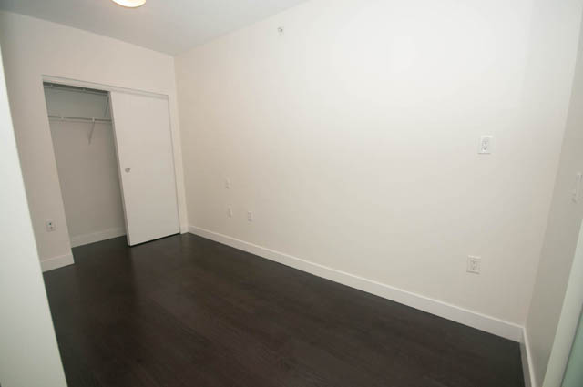 Bright bedroom with hardwood floors and a closet. - 103 - 175 West 2nd, North Vancouver