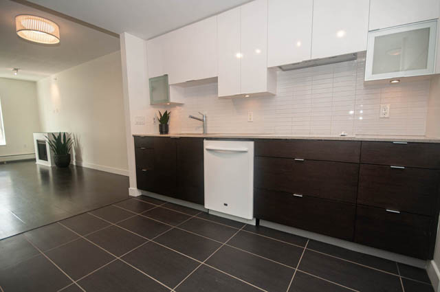 Bright kitchen with dark wood cabinets, white countertops, and a modern design. - 103 - 175 West 2nd, North Vancouver