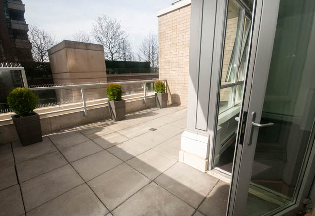 Furnished balcony with tiled flooring and potted plants. - 103 - 175 West 2nd, North Vancouver