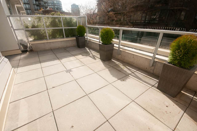 Furnished balcony with stone tiles and potted plants. - 103 - 175 West 2nd, North Vancouver