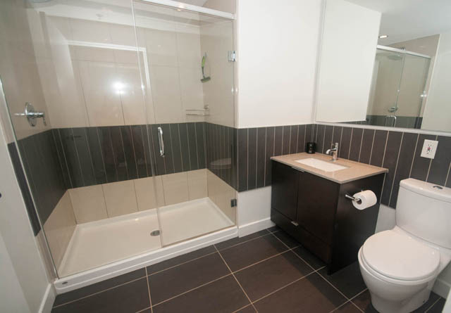 Furnished bathroom with modern fixtures and dark tile walls. - 103 - 175 West 2nd, North Vancouver