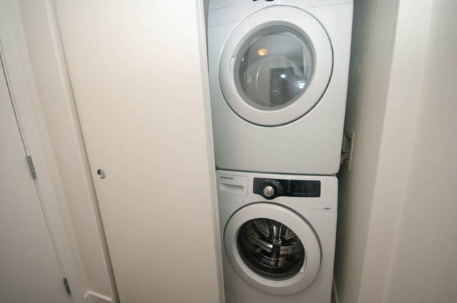 Bright laundry room with white washer and dryer. - 103 - 175 West 2nd, North Vancouver