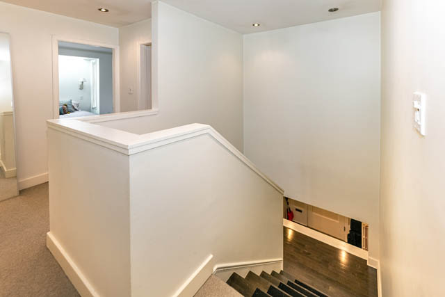 Staircase leading to upper level with white walls and hardwood flooring below. - 4678 West 9th Ave, Vancouver West Side