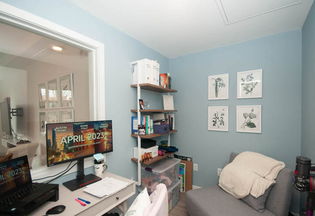 Bright bedroom with blue walls, desk, and wall art. - 211 - 733 E 3rd St, North Vancouver