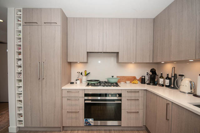 Bright kitchen with light wood cabinets, white countertops, and modern appliances. - 211 - 733 E 3rd St, North Vancouver