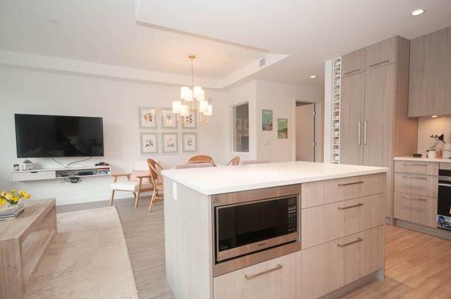 Bright kitchen with light wood cabinets, white countertops, and hardwood floors. - 211 - 733 E 3rd St, North Vancouver