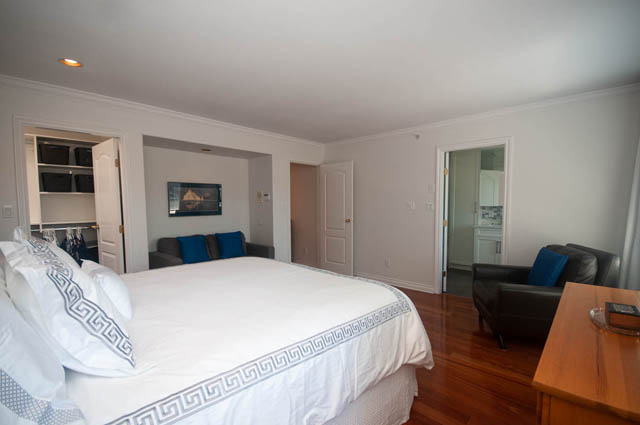 Furnished bedroom with hardwood floors and a cozy bed setup. - Upper  - 2318 West 14th Ave, Vancouver West Side