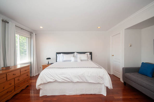 Furnished bedroom with hardwood floors and a cozy bed setup. - Upper  - 2318 West 14th Ave, Vancouver West Side