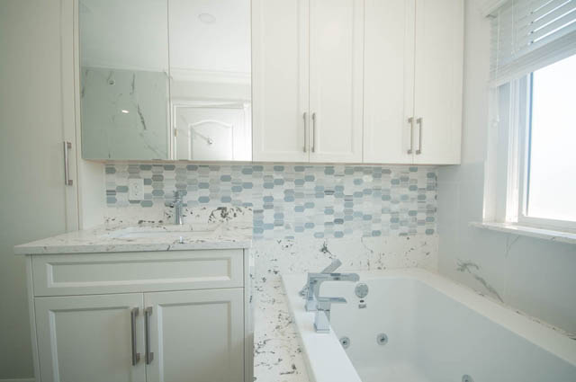 Bright kitchen with white cabinets, marble countertops, and mosaic tile backsplash. - Upper  - 2318 West 14th Ave, Vancouver West Side