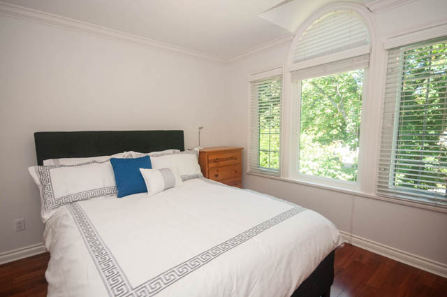 Bright bedroom with white walls, arched window, and wooden floors. - Upper  - 2318 West 14th Ave, Vancouver West Side