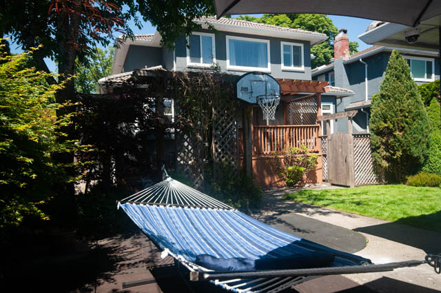 Furnished patio with hammock and basketball hoop, surrounded by greenery. - Upper  - 2318 West 14th Ave, Vancouver West Side