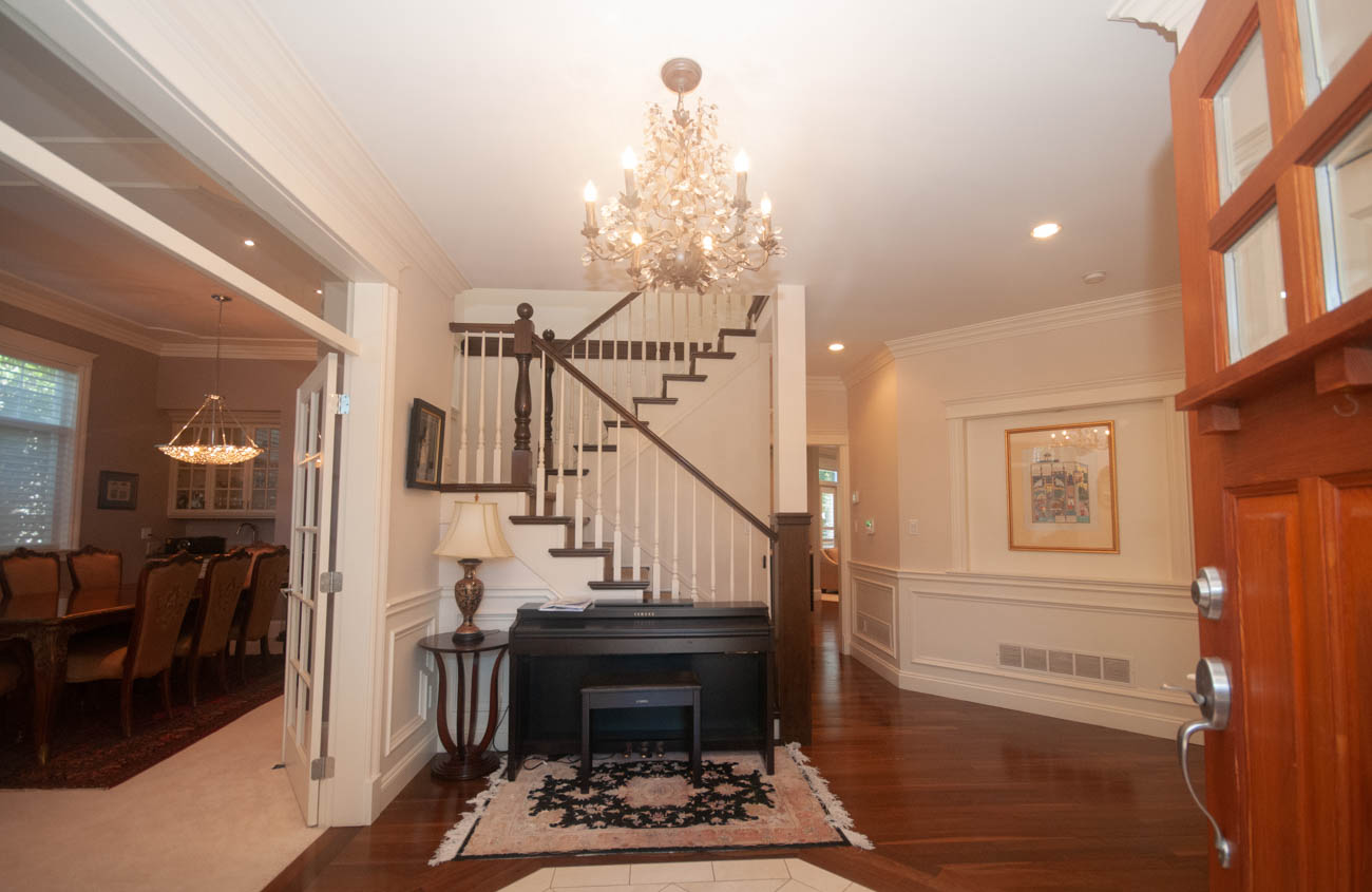 Foyer with chandelier, hardwood floors, and a view of the staircase leading to the second floor. - 3440 Wellington Crescent, North Vancouver
