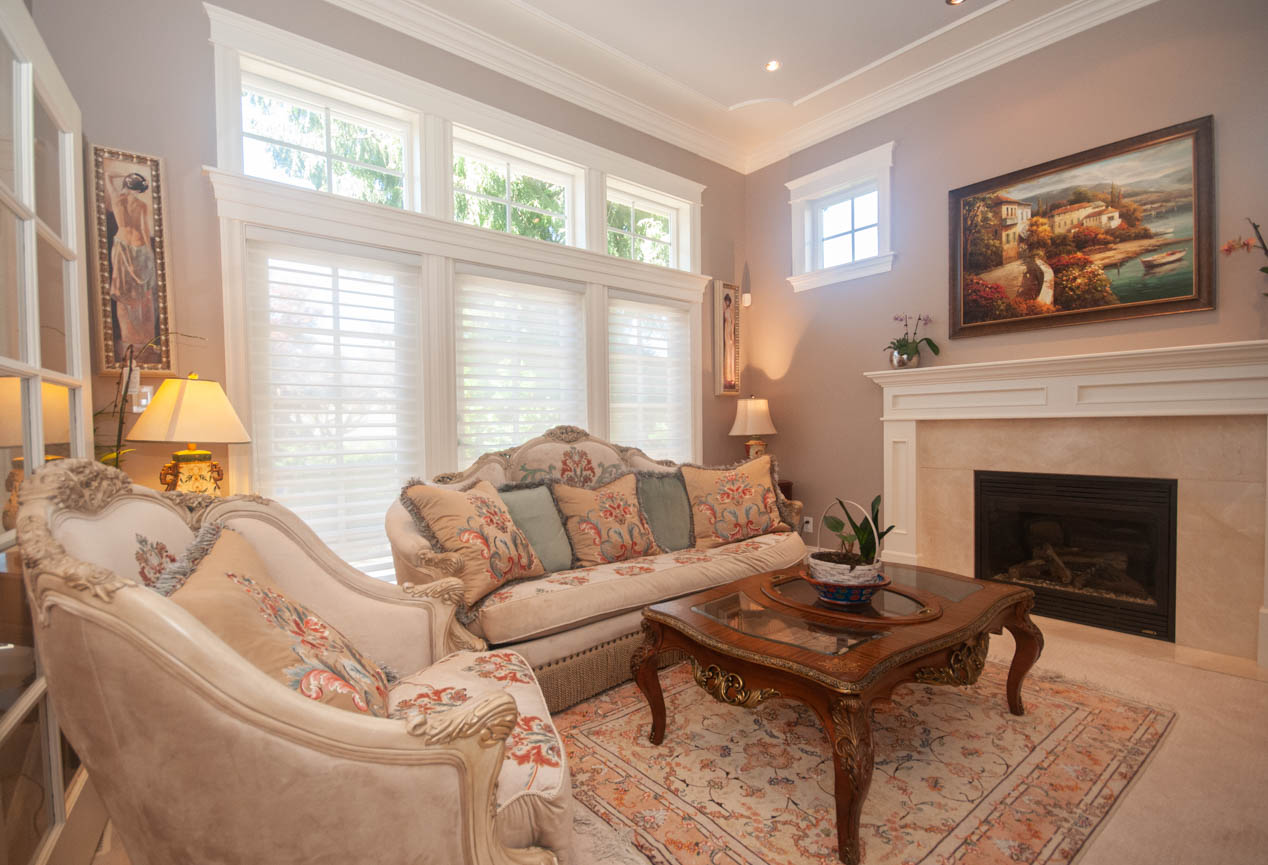Bright living room with ornate furniture, fireplace, and large windows. - 3440 Wellington Crescent, North Vancouver