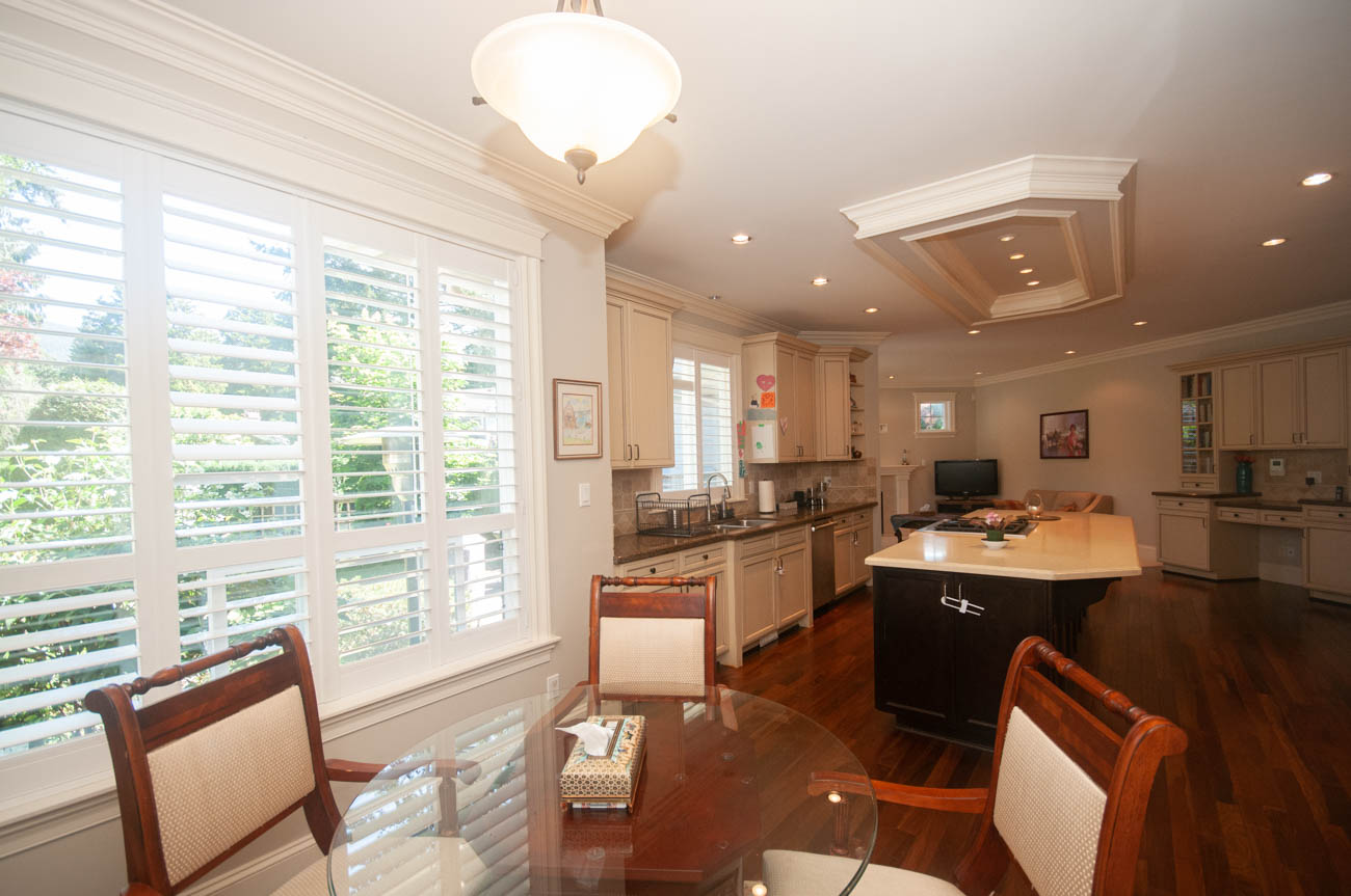 Bright kitchen with hardwood floors, granite countertops, and a view of the city. - 3440 Wellington Crescent, North Vancouver