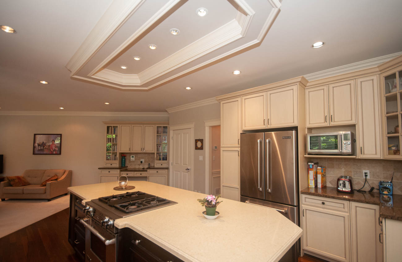 Bright kitchen with granite countertops, stainless steel appliances, and coffered ceiling. - 3440 Wellington Crescent, North Vancouver