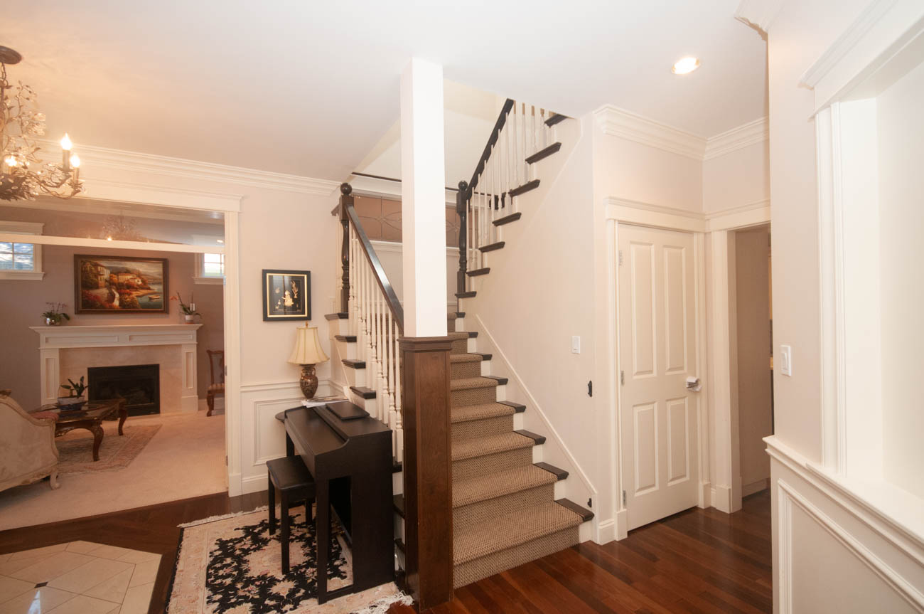 Foyer with hardwood floors, staircase, and chandelier. - 3440 Wellington Crescent, North Vancouver