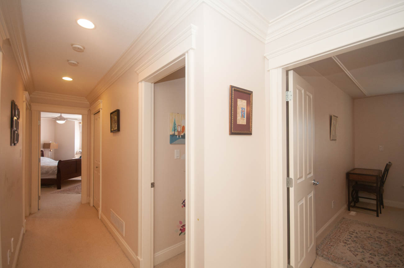 Furnished hallway leading to bedrooms with light-colored walls and carpeted floors. - 3440 Wellington Crescent, North Vancouver