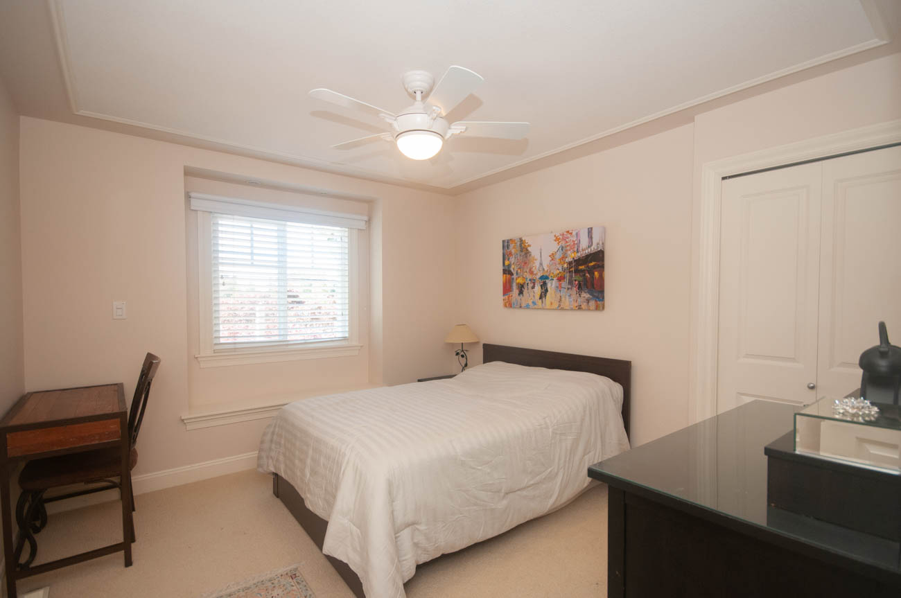 Furnished bedroom with twin beds, desk, and artwork, ceiling fan, and window with blinds. - 3440 Wellington Crescent, North Vancouver