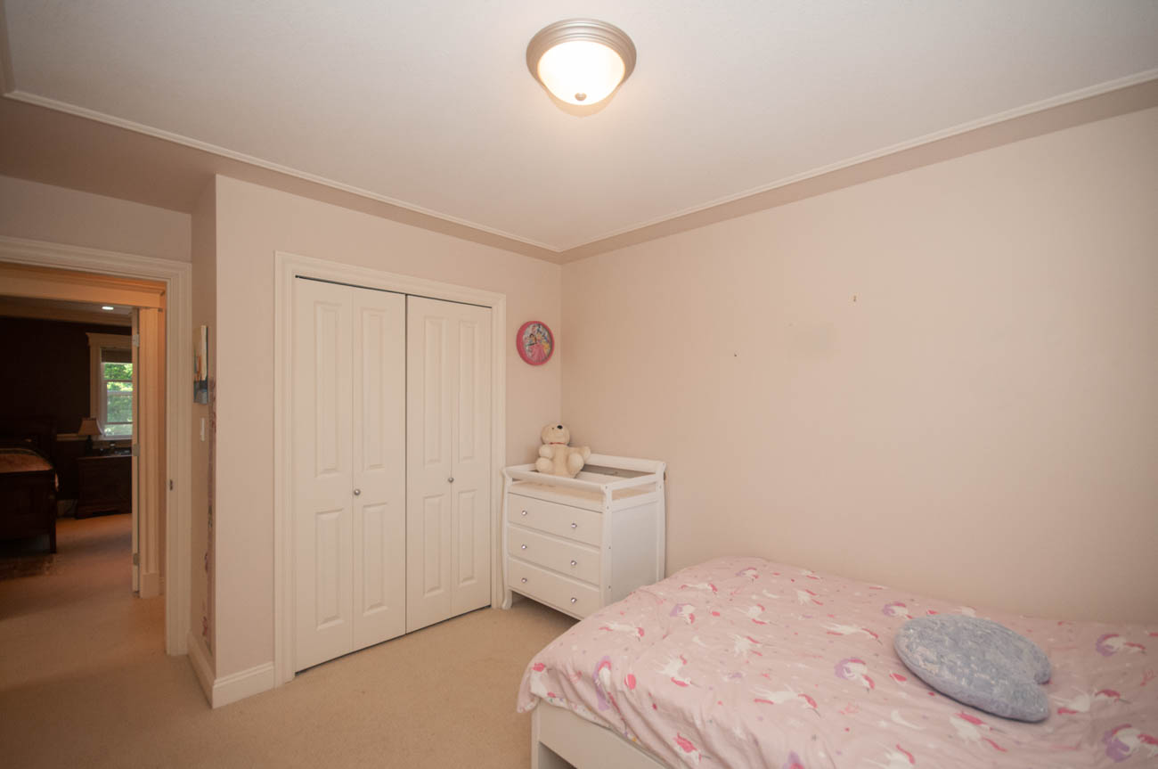 Bright bedroom with twin beds, closet, and pink unicorn bedding. - 3440 Wellington Crescent, North Vancouver