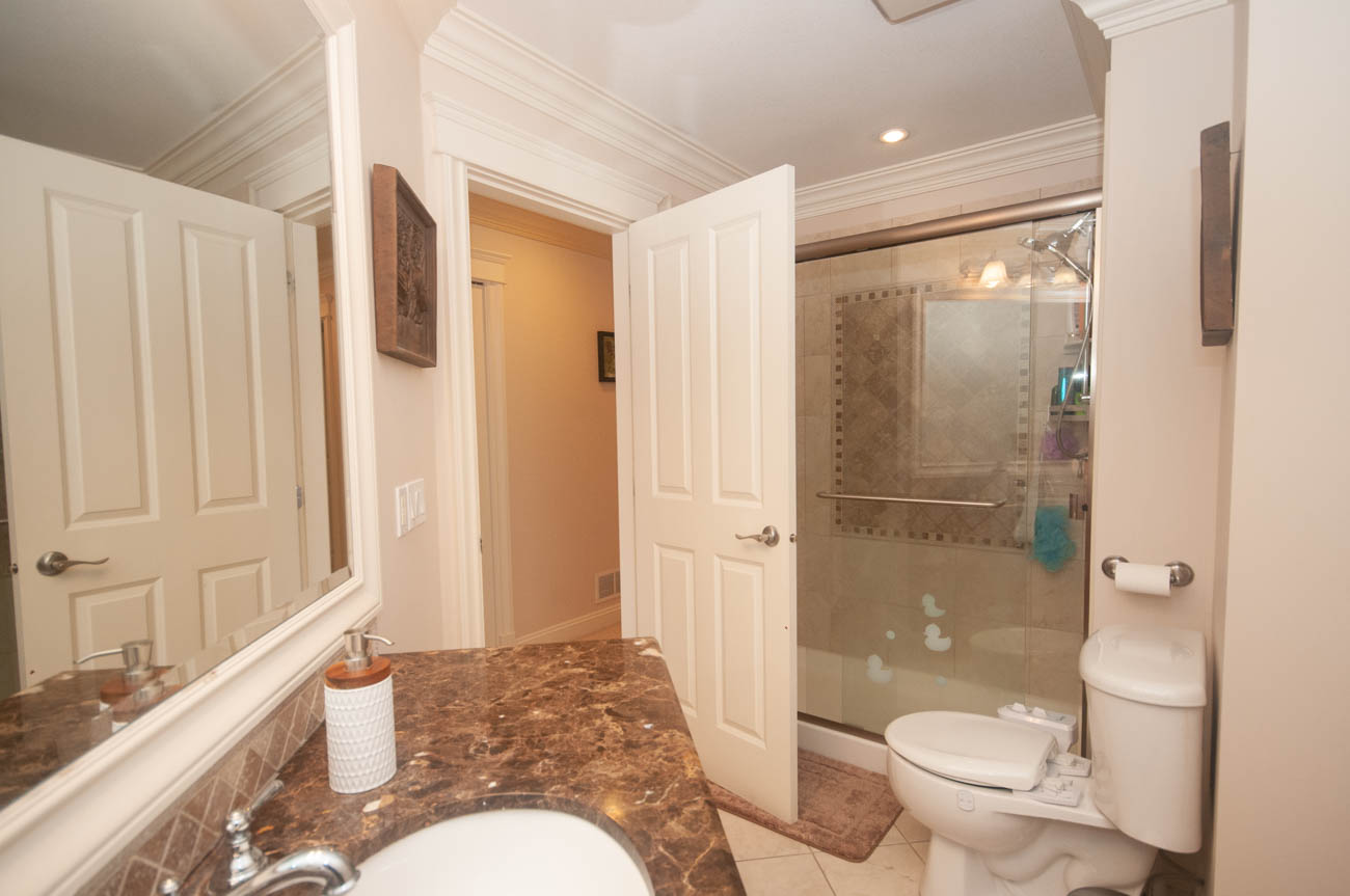 Furnished bathroom with marble countertops and a walk-in shower. - 3440 Wellington Crescent, North Vancouver