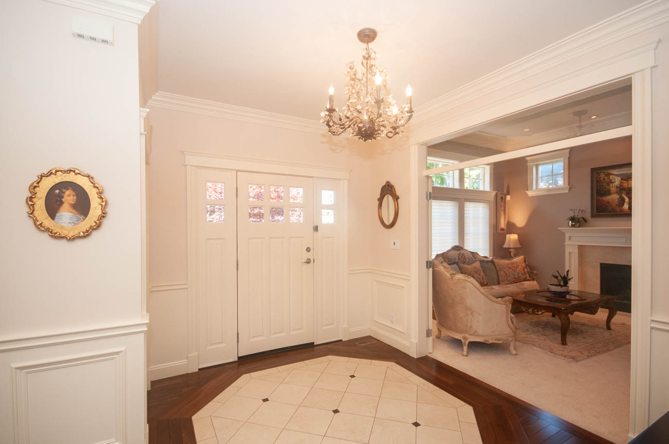 Foyer with white doors, hardwood floors, and a chandelier. - 3440 Wellington Crescent, North Vancouver