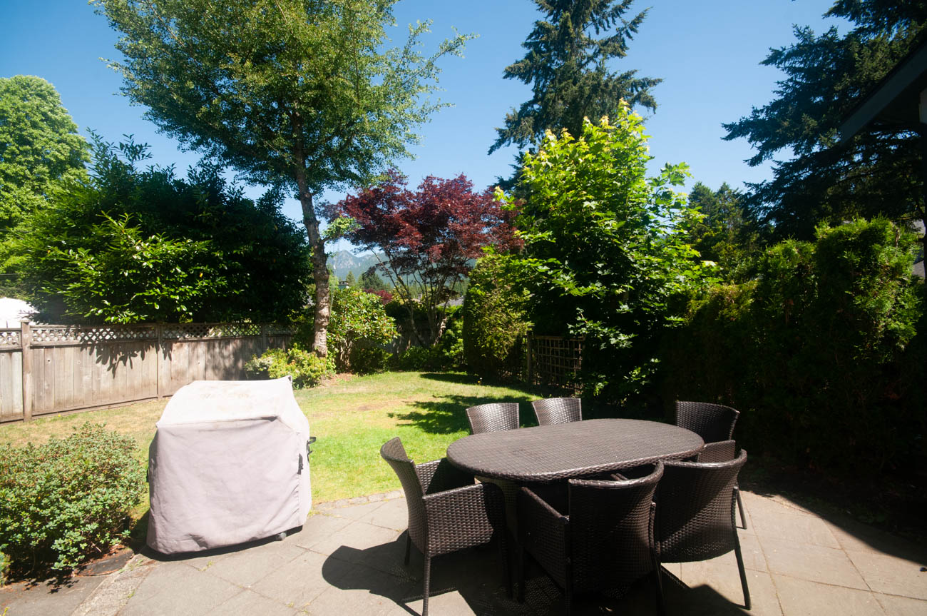 Furnished patio with outdoor furniture and lush greenery. - 3440 Wellington Crescent, North Vancouver