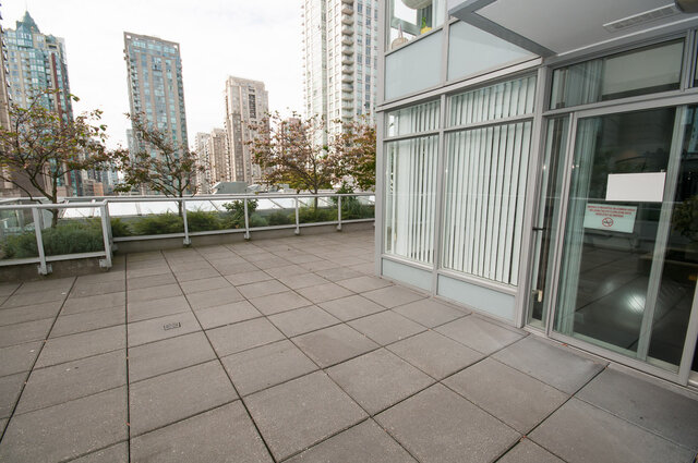 A balcony with tiled flooring, railing with greenery. - 1306-480 Robson Street, Vancouver Downtown