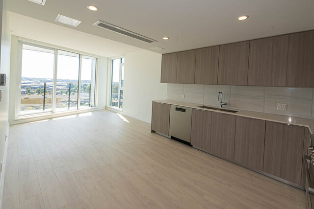 Bright kitchen with hardwood floors, city view, and modern cabinetry. - 1105 - 1401 Hunter Street, North Vancouver