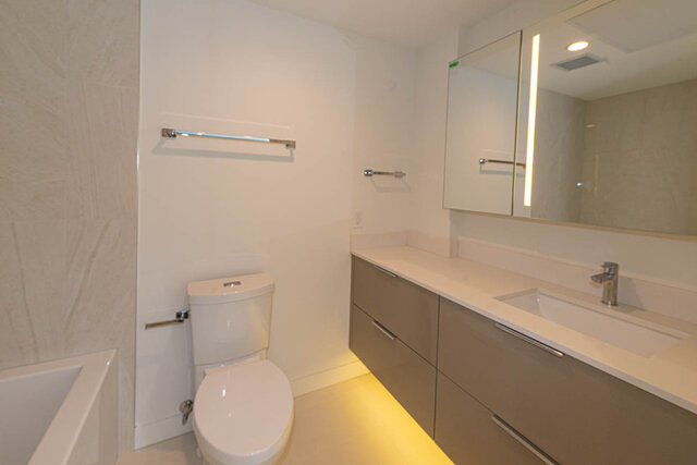 Spacious bathroom with modern vanity, large mirror, and sleek countertop. - 1105 - 1401 Hunter Street, North Vancouver
