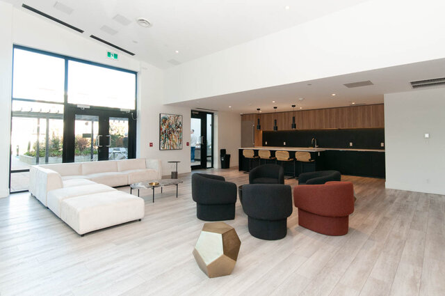 Open-concept living room with modern furniture, hardwood floors, and a kitchen bar. - 1105 - 1401 Hunter Street, North Vancouver