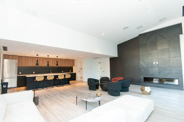 Spacious living room with modern furnishings, marble countertops, and hardwood floors. - 1105 - 1401 Hunter Street, North Vancouver