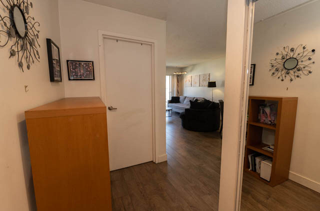 Furnished living room with hardwood floors and a cozy sofa. - 306 - 212 Forbes Ave, North Vancouver