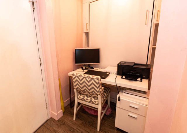 Bright and cozy bedroom with a desk, chair, and small TV, featuring hardwood floors and a closet. - 306 - 212 Forbes Ave, North Vancouver