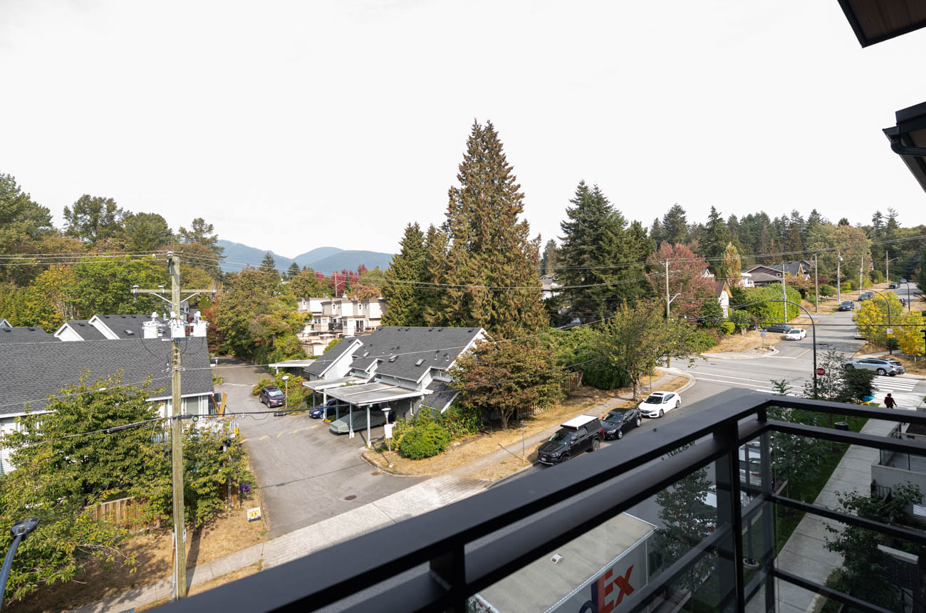 Bright balcony with city view and lush greenery. - 308 - 715 W15th Street, North Vancouver