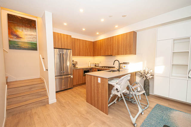 Bright kitchen with wooden cabinets, hardwood floors, and stainless steel appliances. - 30 - 533 East 3rd st., North Vancouver