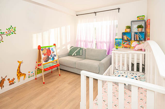 Bright living room with hardwood floors, a crib, and a colorful play area. - 30 - 533 East 3rd st., North Vancouver